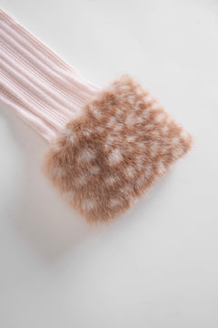 Pair of pink ribbed socks with a brown fuzzy sole on a light deer print